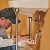 Plumber tightens a sink drain