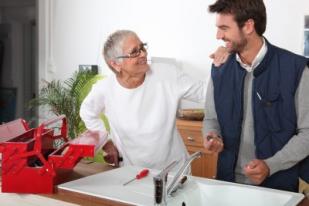 San Bruno plumbing technician talks with a customer while installing a sink